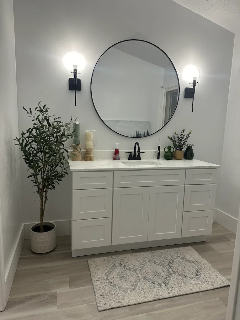 Bathroom with white vanity and round mirror