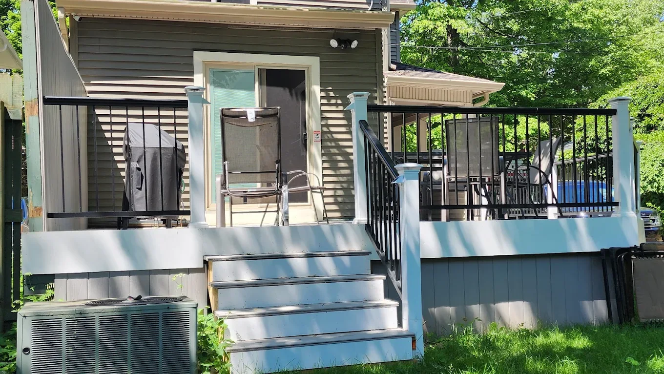 Raised backyard deck with stairs and black railings