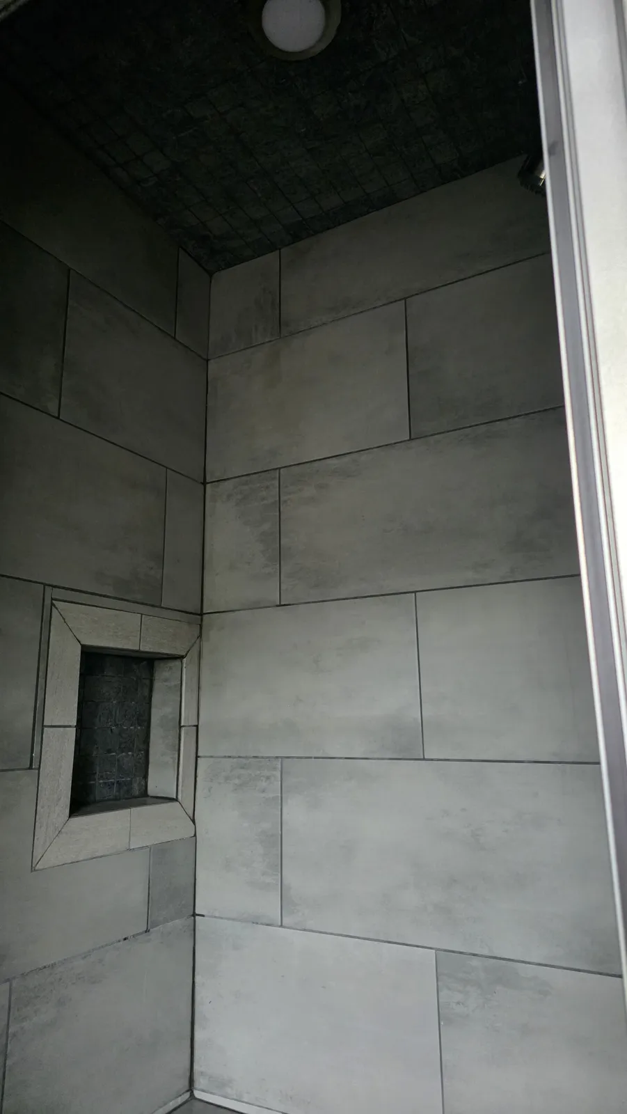 Walk-in shower with large gray wall tile
