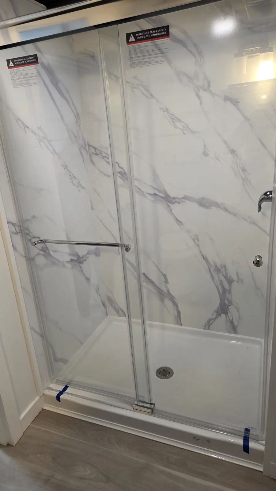 Glass shower enclosure with marble-look walls