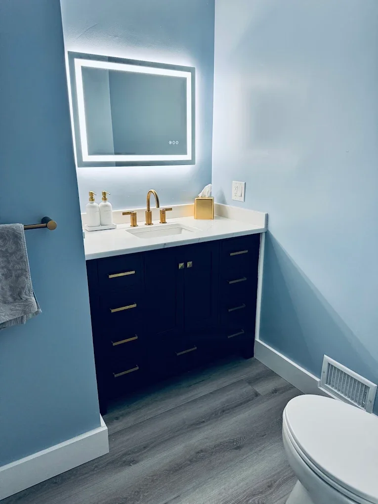 Bathroom with blue vanity and modern mirror