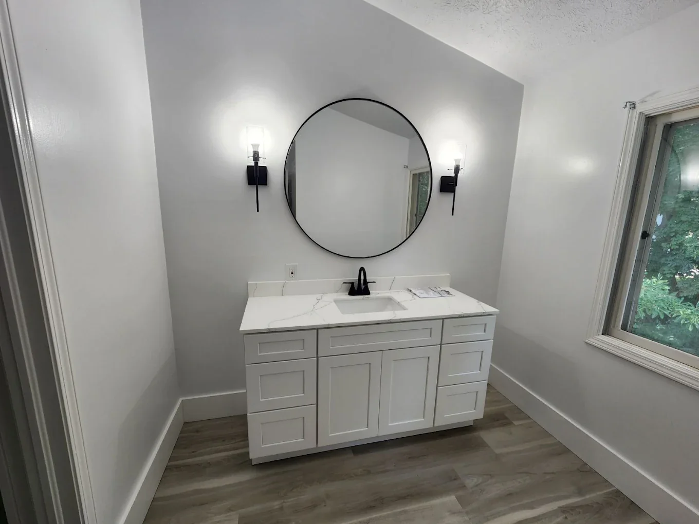 Updated bathroom vanity with round mirror