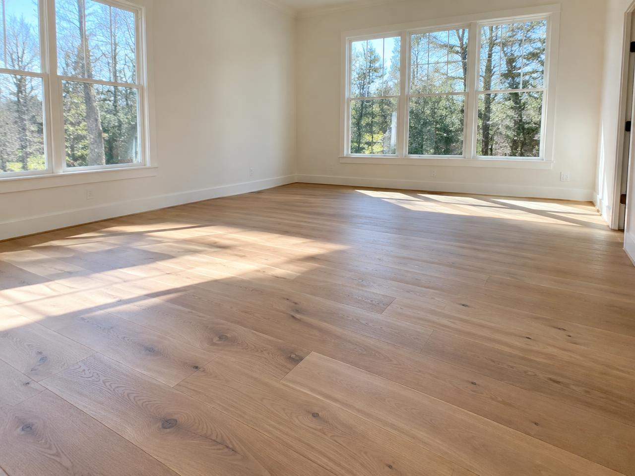 Newly installed wide plank oak hardwood floor in a sunlit room